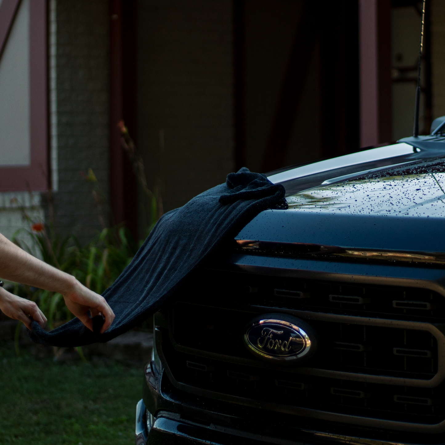 Person cleaning a Ford vehicle with a microfiber drying towel