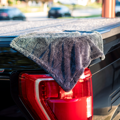 Gray microfiber towel draped over a red car tail light with a blurred background