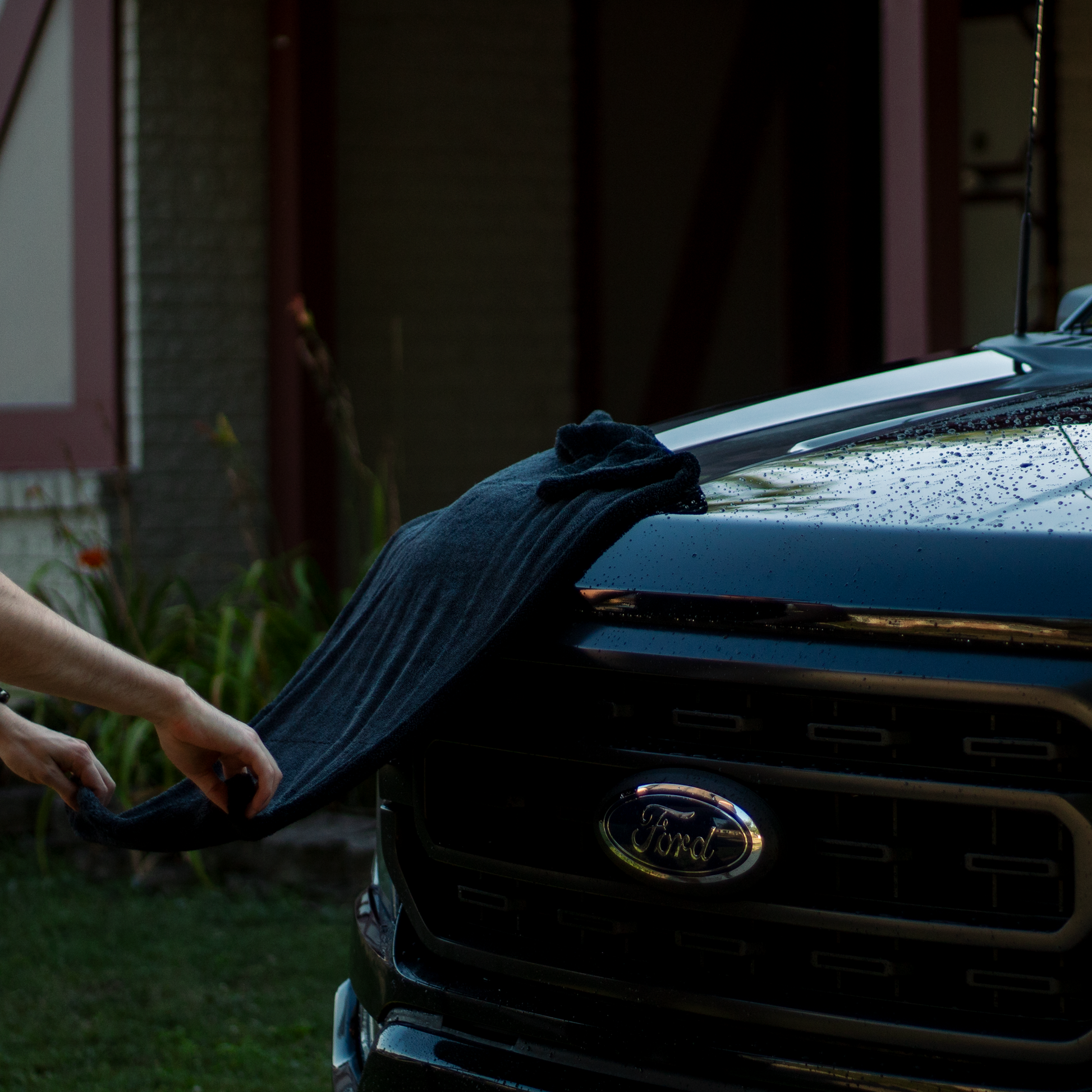 Person cleaning a Ford vehicle with a microfiber drying towel